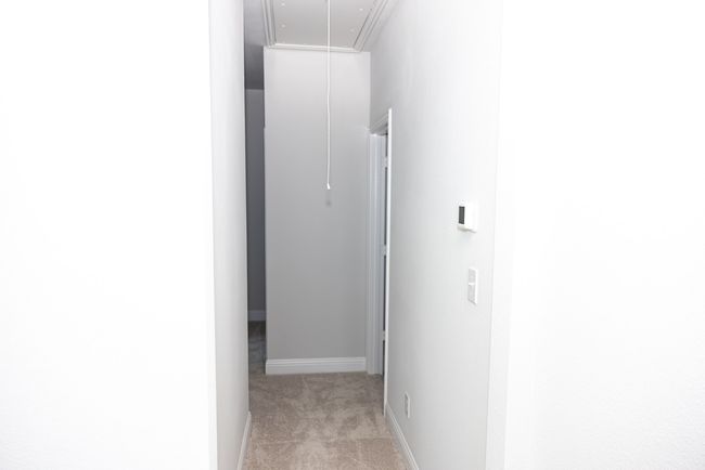 Hallway with attic access and light carpet | Image 23