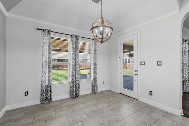 Unfurnished dining area with a chandelier, ornamental molding, and arched walkways | Image 13