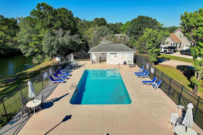 Community pool featuring a patio and view of scattered trees | Image 31