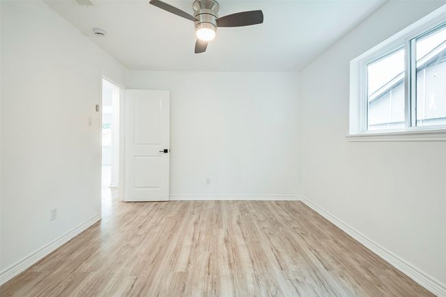 Unfurnished room featuring light wood-type flooring, a ceiling fan, and a smoke detector | Image 23