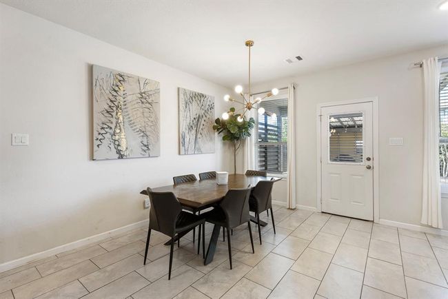 Dining area with upgraded modern lighting and plenty of natural light - perfect for everyday meals. | Image 15