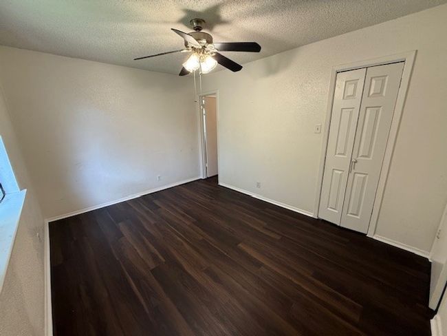 Spare room with a ceiling fan, dark wood-style flooring, and a textured ceiling | Image 9