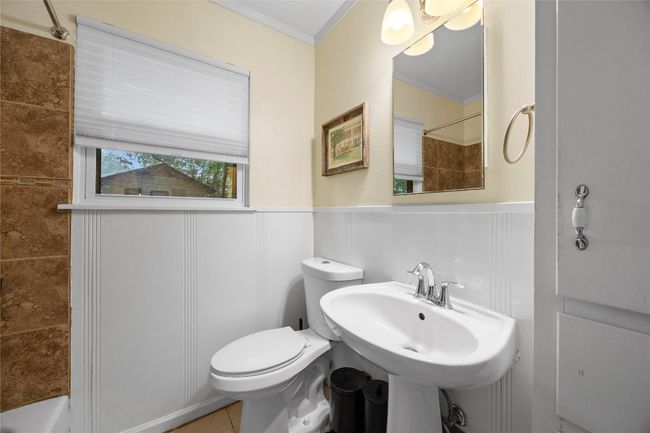 Bathroom with a wainscoted wall, a shower, ornamental molding, a decorative wall, and tile patterned floors | Image 15