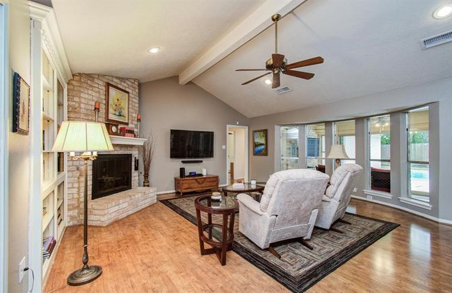 Charming brick corner fireplace with gas logs. Large bay window with sweeping views of private backyard and pool. | Image 9