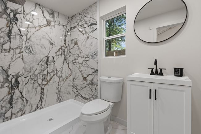 Bathroom with vanity, marble finish floors, a marble finish shower, toilet, and baseboards | Image 25