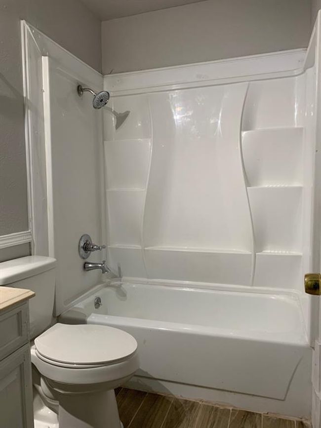 Full bathroom with shower / tub combination, hardwood / wood-style flooring, toilet, and vanity | Image 7