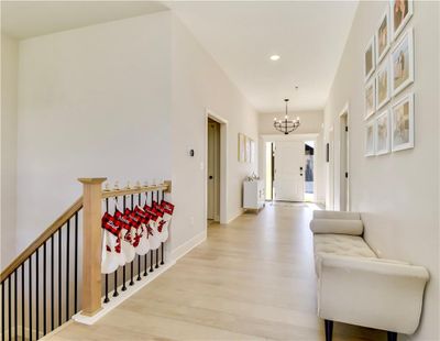 Hallway featuring an inviting chandelier and light hardwood / wood-style flooring | Image 3