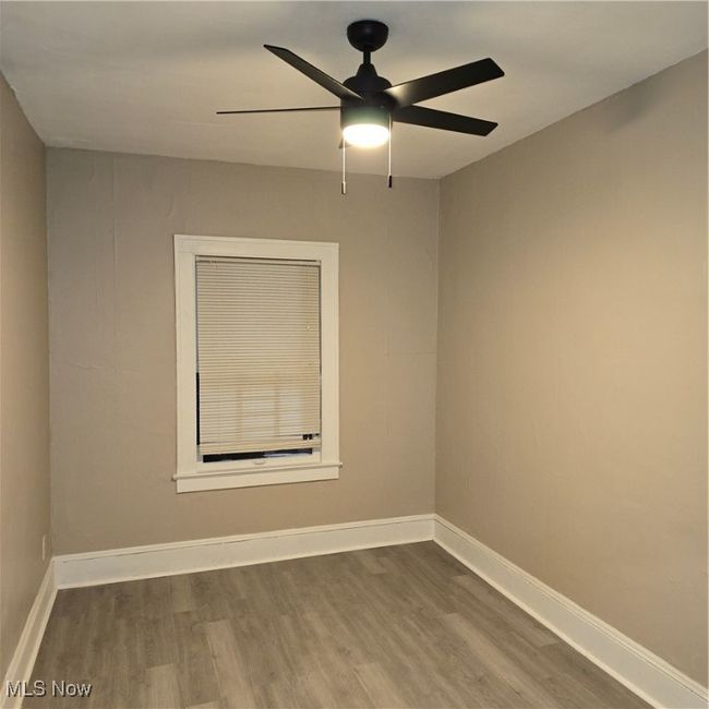 Empty room featuring wood finished floors, baseboards, and ceiling fan | Image 4