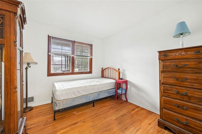 Bedroom with baseboards, visible vents, and light wood finished floors | Image 9