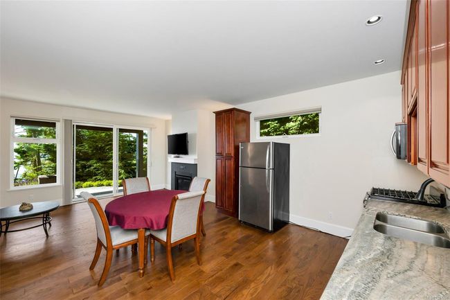 Dining space with healthy amount of natural light, dark wood-style floors, recessed lighting, and a glass covered fireplace | Image 56