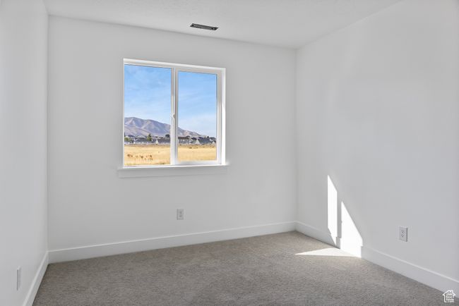 Empty room with baseboards, visible vents, carpet floors, and a mountain view | Image 23