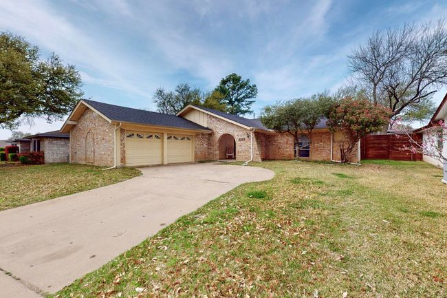 Ranch-style house featuring brick siding, concrete driveway, a front lawn, and an attached garage | Image 5