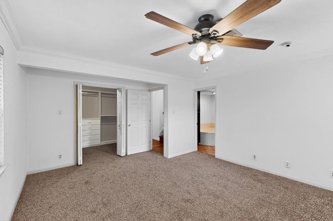 Unfurnished bedroom featuring carpet, crown molding, a closet, and ceiling fan | Image 13