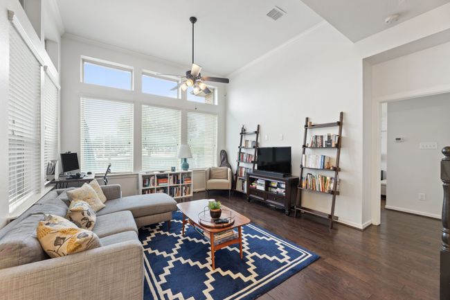 Living room featuring a ceiling fan, wood finished floors, crown molding, and baseboards | Image 12