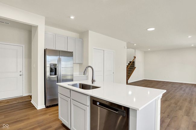 kitchen featuring a kitchen island with sink, wood finished floors, stainless steel appliances, and a sink | Image 12