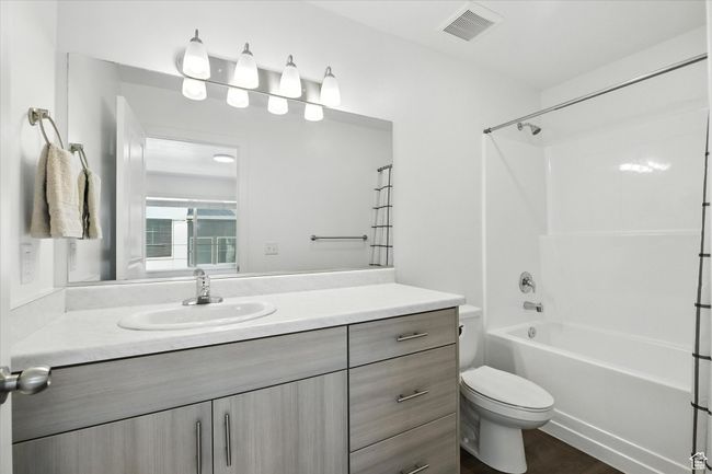 Full bath featuring vanity, washtub / shower combination, and wood finished floors | Image 13