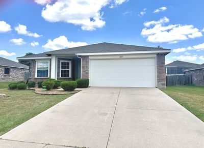 Ranch-style house featuring a garage and a front yard | Image 1