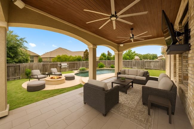 Fenced backyard featuring a patio, an outdoor living space with a fire pit, grilling area, and a ceiling fan | Image 28