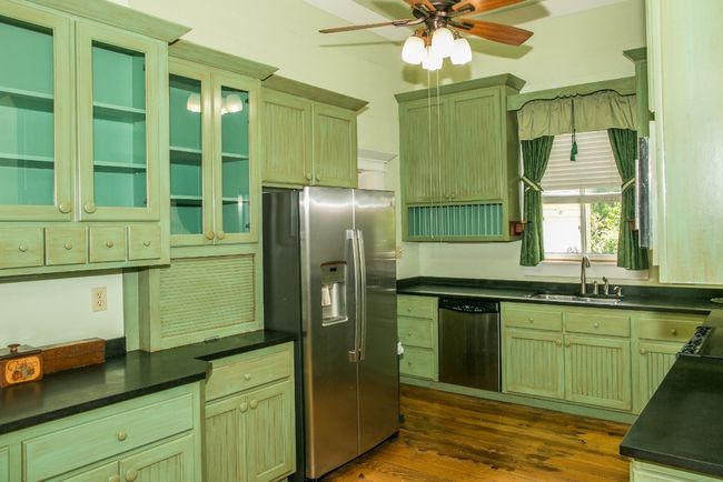 Kitchen featuring appliances with stainless steel finishes, a ceiling fan, green cabinetry, and dark countertops | Image 12