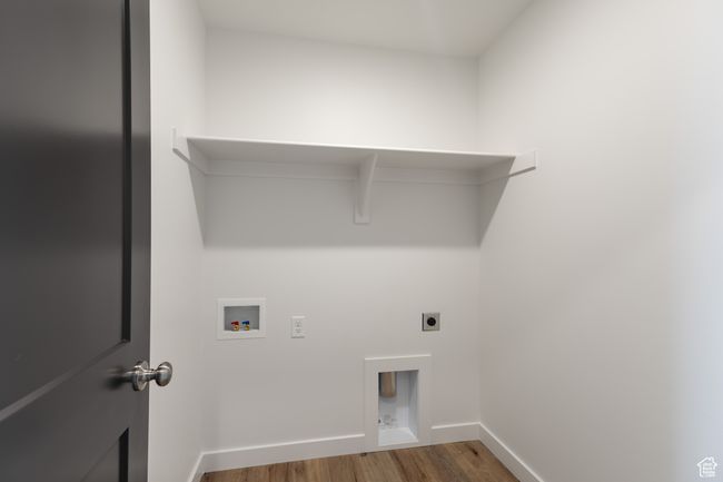 Laundry room with hookup for an electric dryer, wood finished floors, hookup for a washing machine, and baseboards | Image 16