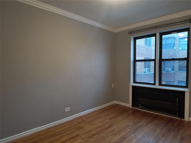 Spare room featuring baseboards, wood finished floors, and ornamental molding | Image 20