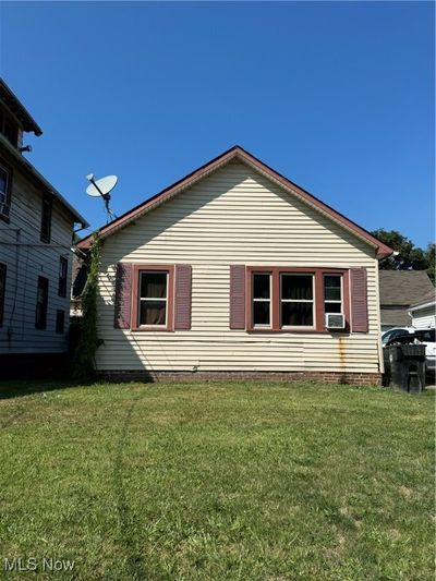 Rear view of house with a lawn and cooling unit | Image 1