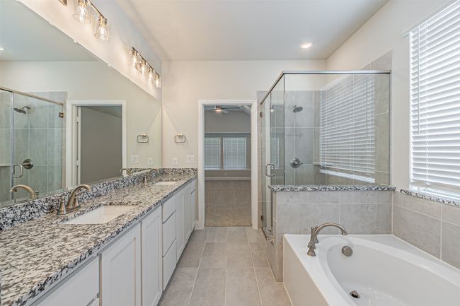 Bathroom with double vanity, a ceiling fan, plenty of natural light, and a garden tub | Image 30