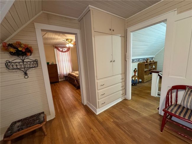Hall with light wood-type flooring, wood walls, wooden ceiling, and vaulted ceiling | Image 29