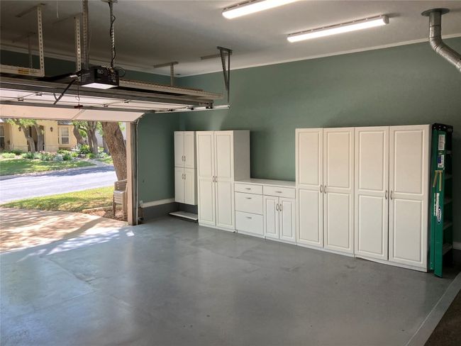 View of left side of the garage to display all of the extra cabinetry and storage over the garage door. | Image 33