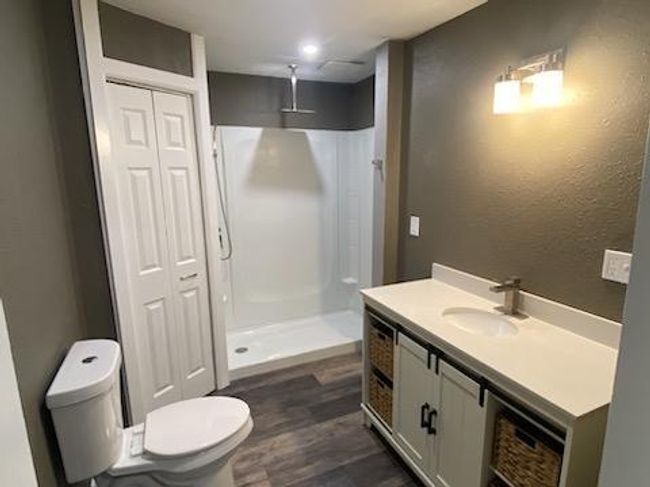 Bathroom featuring walk in shower, hardwood / wood-style flooring, toilet, and vanity | Image 19