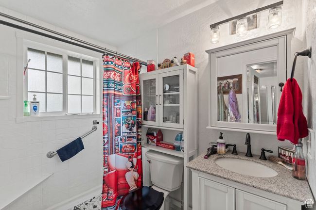 Bathroom featuring toilet, vanity, and a shower with shower curtain | Image 18