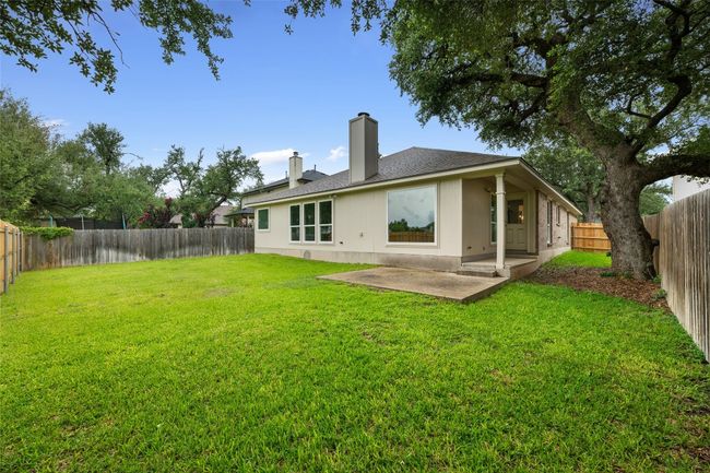 Back of property with a patio area, a chimney, a fenced backyard, and a shingled roof | Image 36