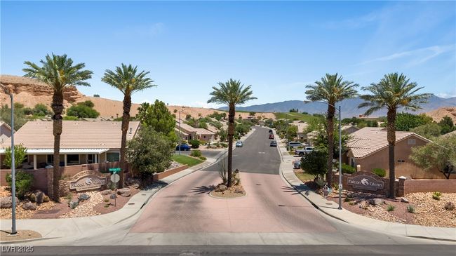 View of asphalt road with curbs, a mountain view, street lighting, and a residential view | Image 50