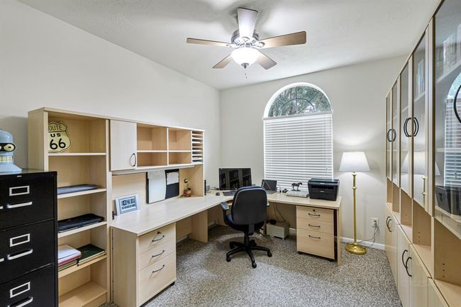 Secondary bedroom #1 with low-pile carpet, ceiling fan and big windows. Currently used as office. | Image 15