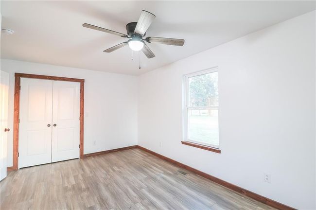 Unfurnished bedroom with a closet, light hardwood / wood-style flooring, and ceiling fan | Image 32