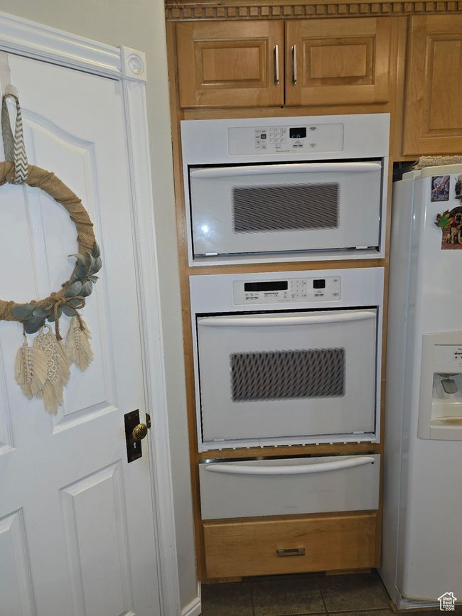 Room details with brown cabinetry, a warming drawer, and white appliances | Image 21
