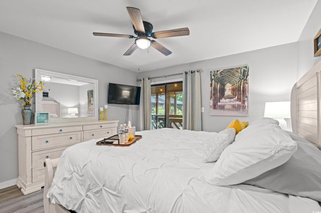 Bedroom featuring access to outside, wood finished floors, baseboards, and a ceiling fan | Image 15