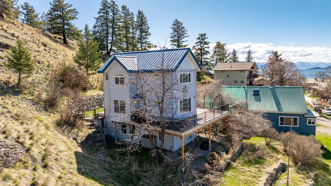Rear view of house featuring a wooden deck and metal roof | Image 48