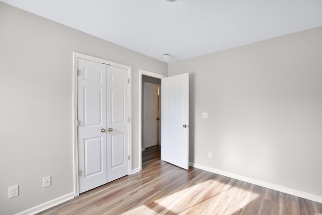 Unfurnished bedroom with light wood finished floors and a closet | Image 4