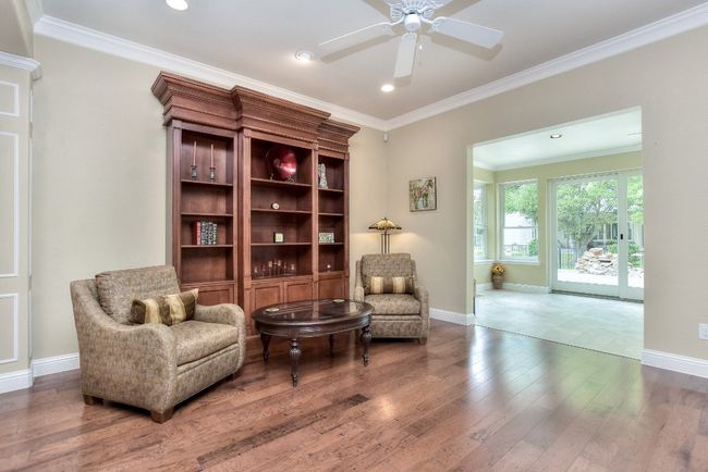 Great open view from den back through Sun room to patio. Custom bookshelf is not attached but can stay. Note: was originally in library. | Image 5