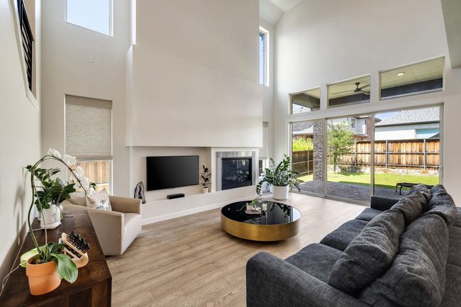 Living room featuring a high ceiling, healthy amount of natural light, and wood finished floors | Image 14
