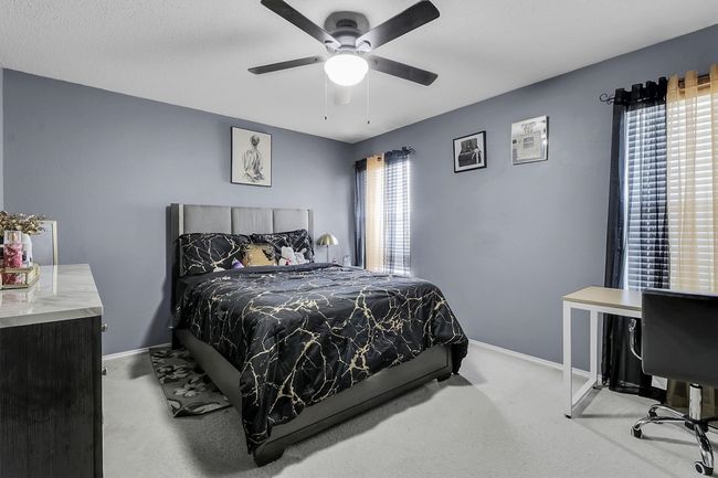 Carpeted bedroom with multiple windows, a ceiling fan, and baseboards | Image 14