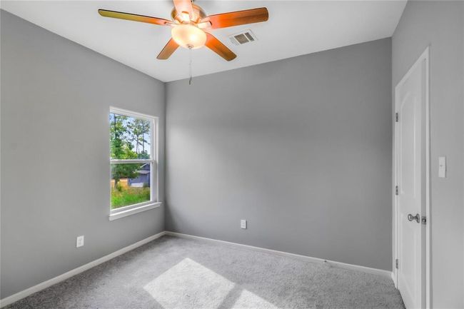 Secondary bedroom with neutral colors, 9' ceiling, ceiling fan and natural light. | Image 12