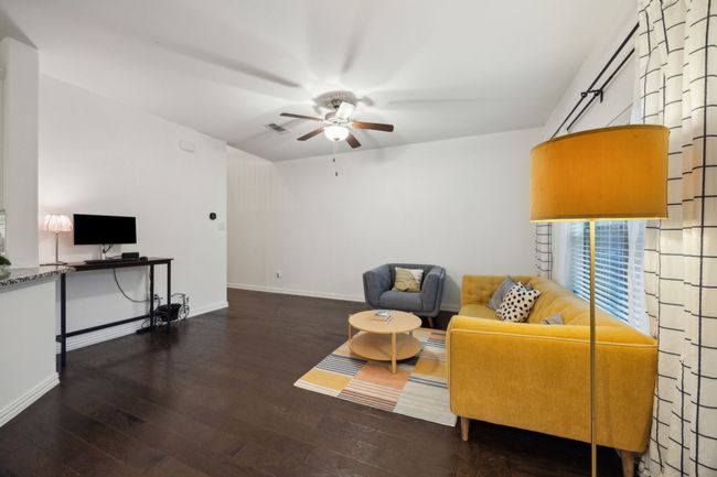 Living area featuring ceiling fan, baseboards, hardwood / wood-style flooring, and visible vents | Image 5