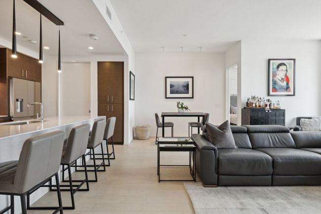 Living room with light wood finished floors, recessed lighting, and a bar | Image 9