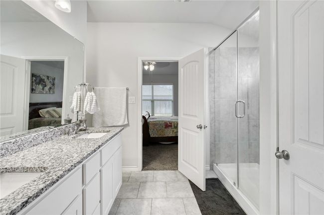 Bathroom with tile patterned flooring, vaulted ceiling, vanity, and a shower with shower door | Image 21