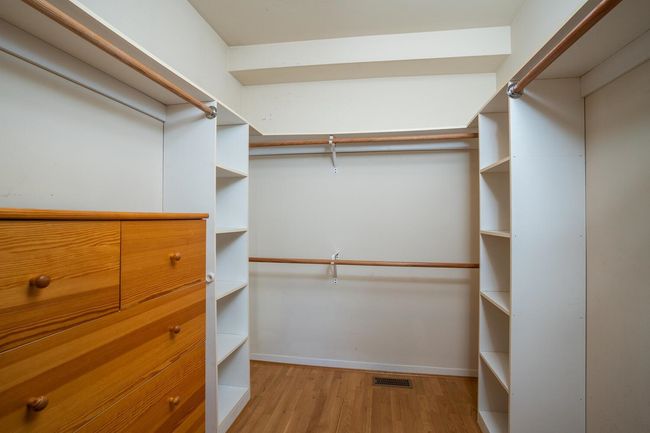 Walk in closet featuring light wood finished floors and visible vents | Image 18
