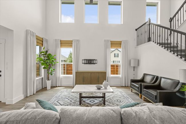 Living room with a high ceiling, stairway, and light wood-style flooring | Image 14