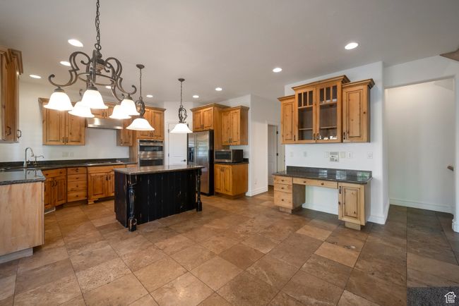 Kitchen with a center island, recessed lighting, appliances with stainless steel finishes, and stone tile flooring | Image 7