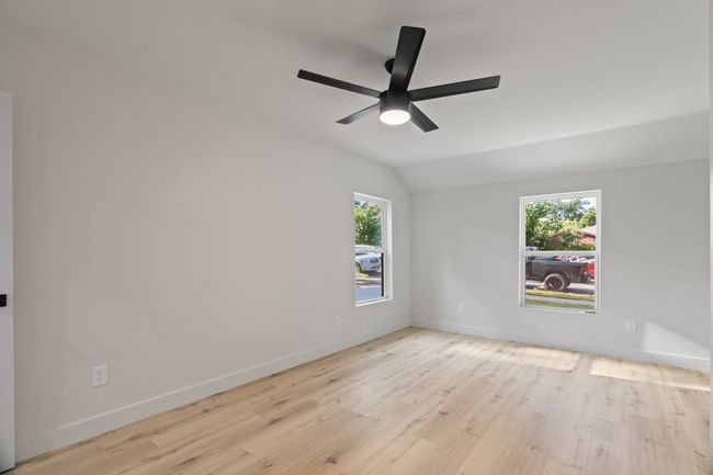 Spare room featuring lofted ceiling, wood finished floors, ceiling fan, and baseboards | Image 11